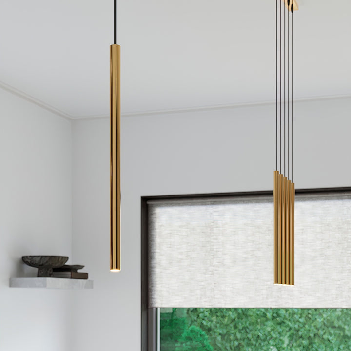 Suspensions tubes fins doré dans un intérieur contemporain