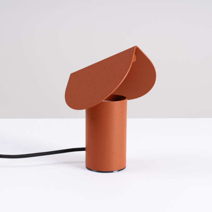 Lampe à poser BISCUIT ocre rouge éteinte, sur une table