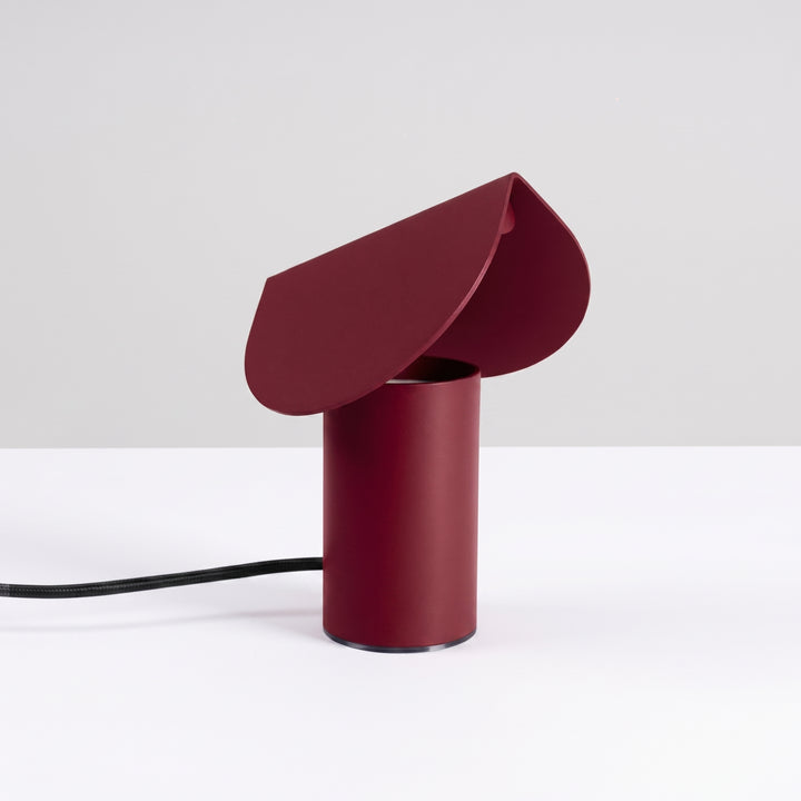 Lampe à poser BISCUIT bordeaux éteinte, sur une table