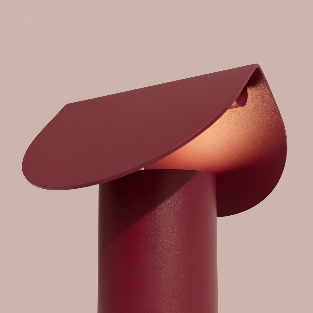 Lampe à poser BISCUIT bordeaux allumée, vue de trois quarts