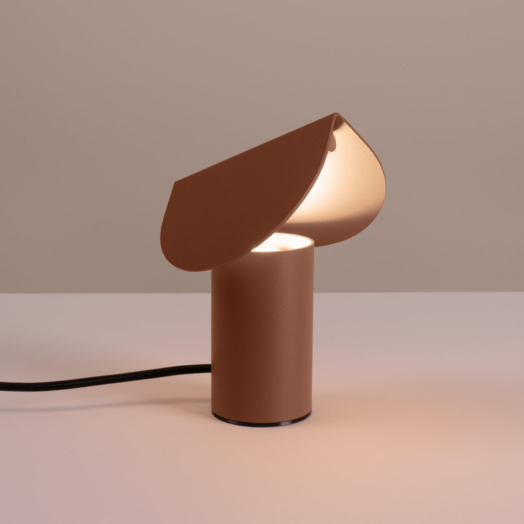 Lampe à poser BISCUIT moka allumée, sur une table