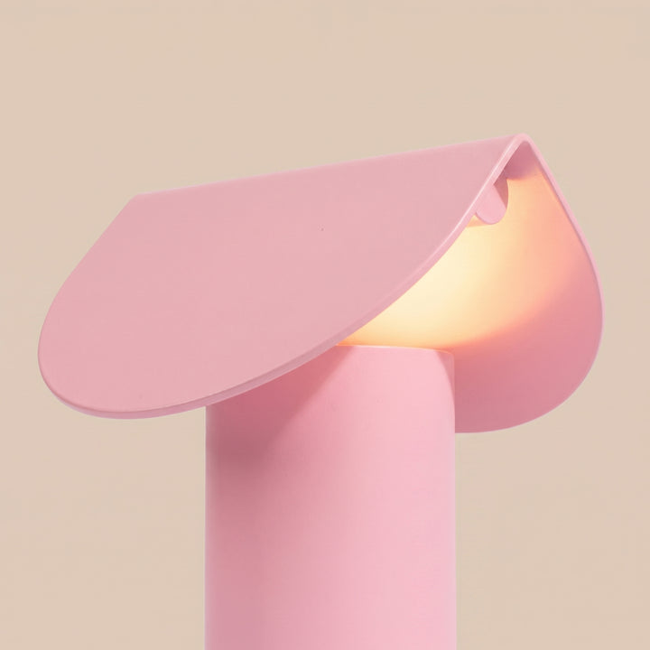 Lampe à poser BISCUIT rose allumée, vue de trois quarts