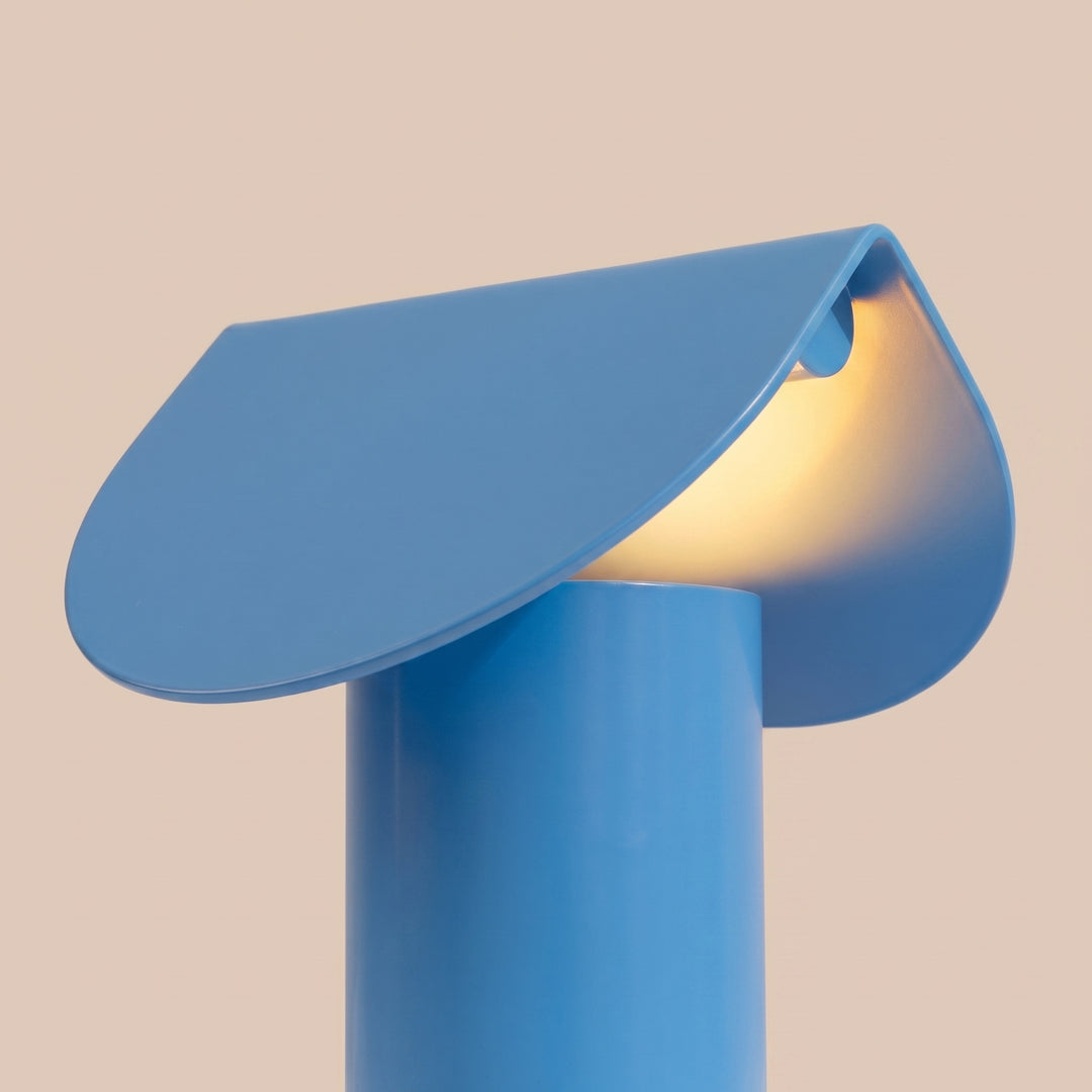 Lampe à poser BISCUIT bleu clair allumée, vue de trois quarts