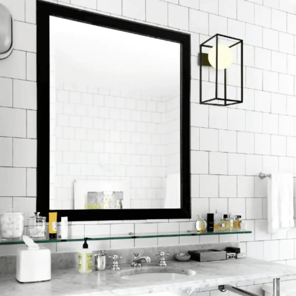 Applique murale daisy en verre opaque avec cadre noir design classique, montée au-dessus d’un plan de travail en marbre