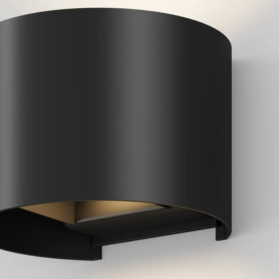 Applique extérieure fulton volume arrondi en cylindre noir mat avec double faisceau et lumière intérieure chaleureuse