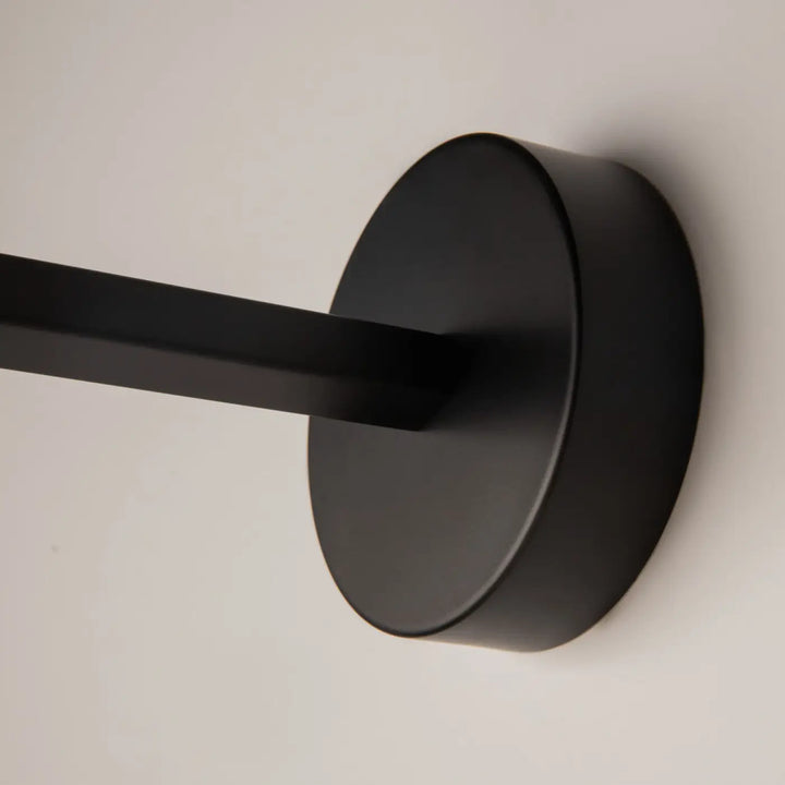 Applique murale long bras en métal noir avec tête ronde et finition mate pour éclairage mural moderne