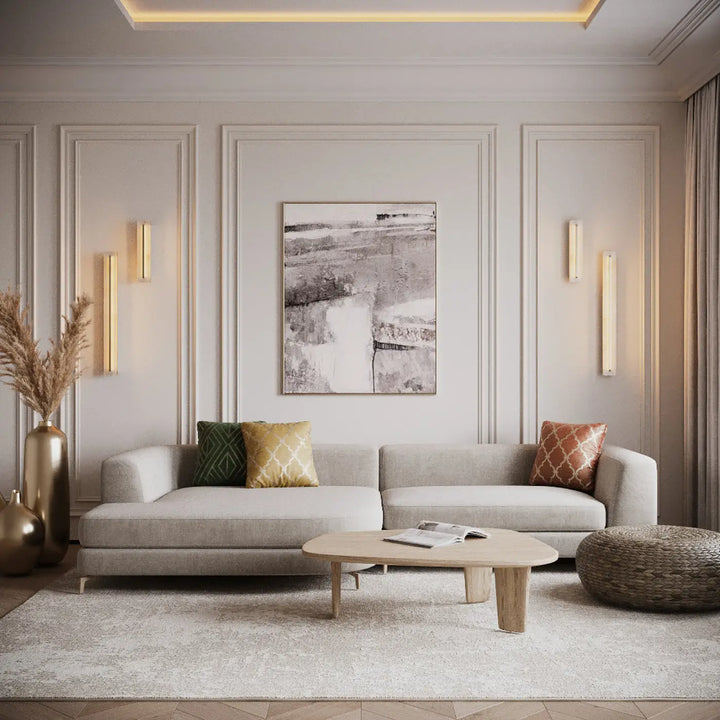 Applique murale albatre avec trois longueurs près dun canapé sectionnel beige au design moderne et minimaliste