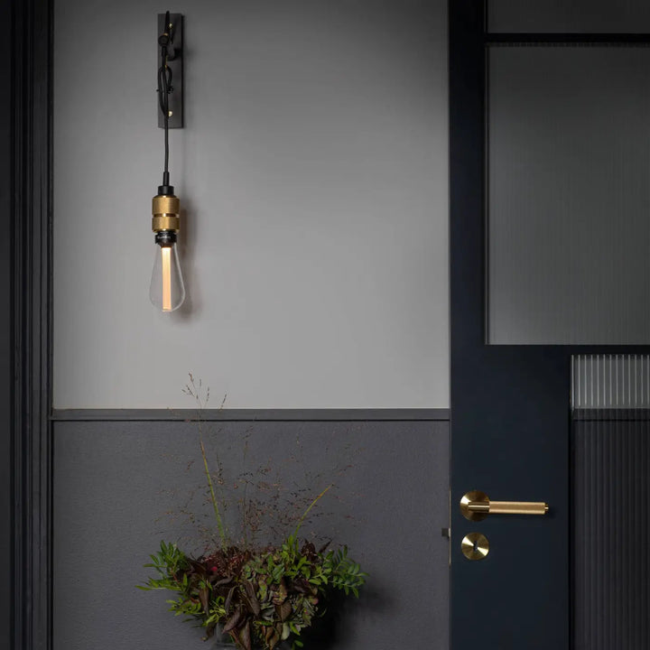 Applique murale Hooked Nude en laiton avec son ampoule, dans un intérieur #couleur_dor
