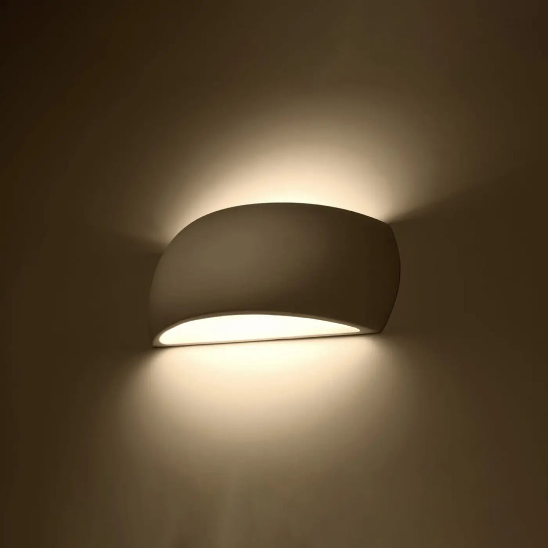 L’applique murale pontius en céramique blanche avec lumière douce et design courbé pour une ambiance chaleureuse