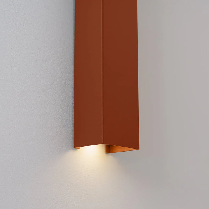 Applique murale FREYA ocre rouge allumée, détail de la sortie de lumière