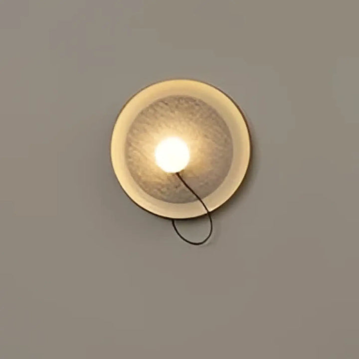 Applique murale contemporaine orluna circulaire avec lumière chaude et finition métallique texturée