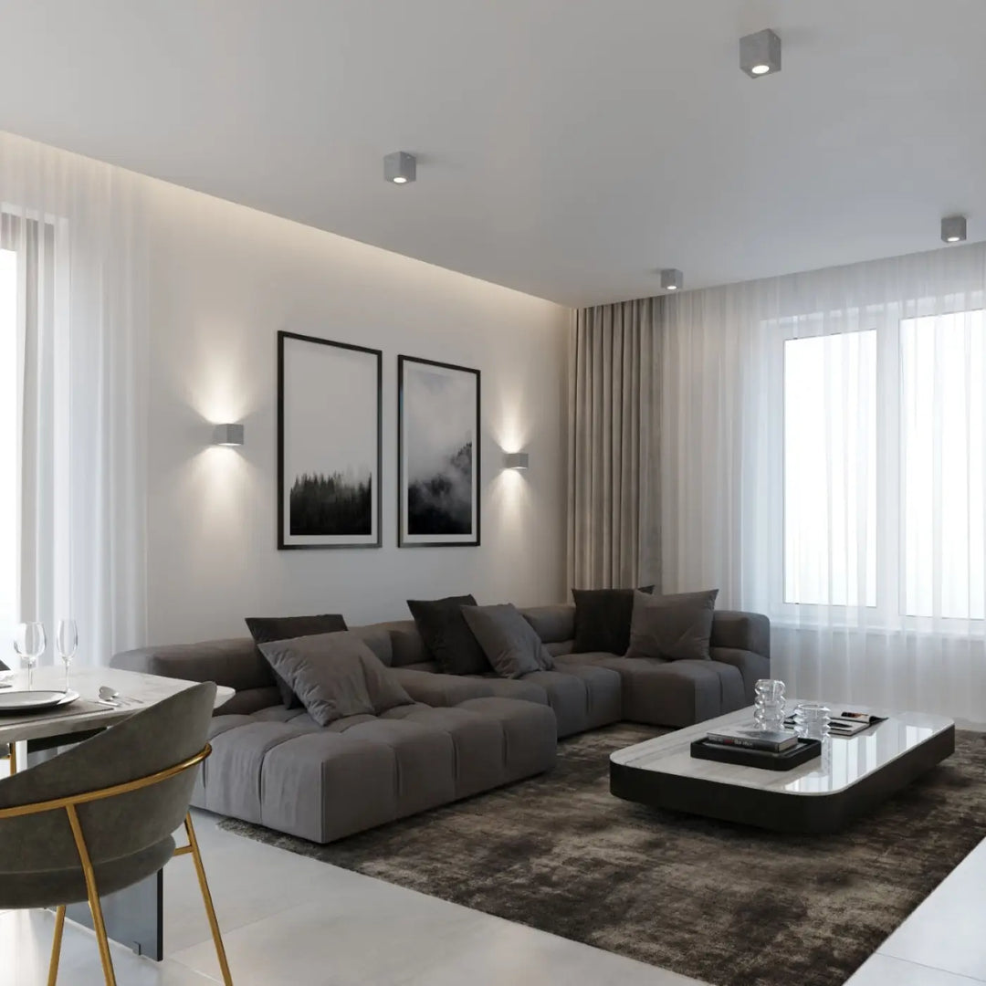Sectionnel modulaire gris avec coussins capitonnés et oreillers gris foncé devant une applique murale quad béton pour une magnifique décoration