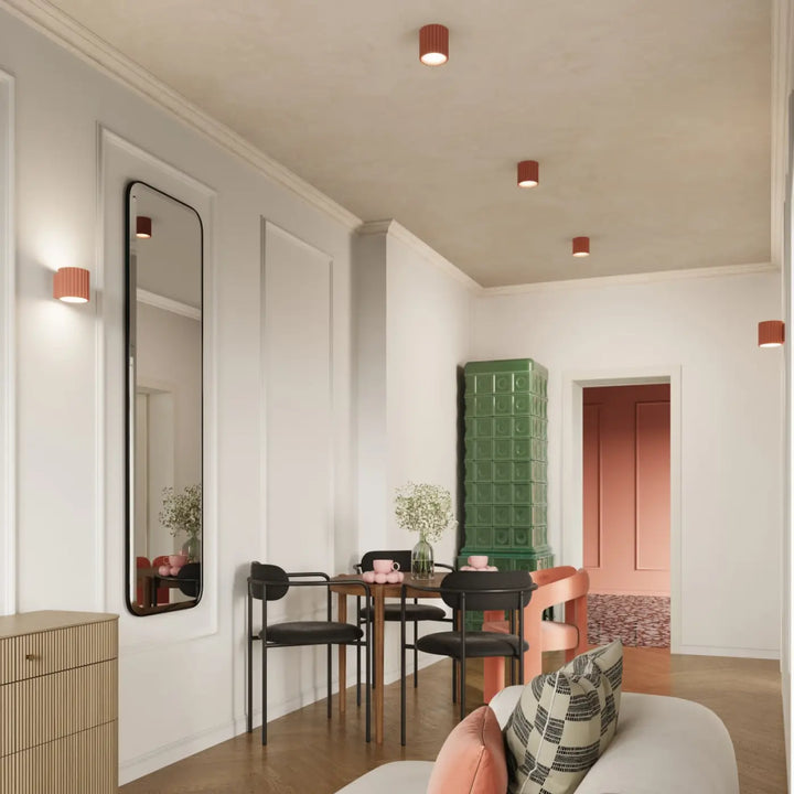 Applique murale aura peach avec forme unique inspirée dans une salle à manger moderne avec chaises noires et table en bois