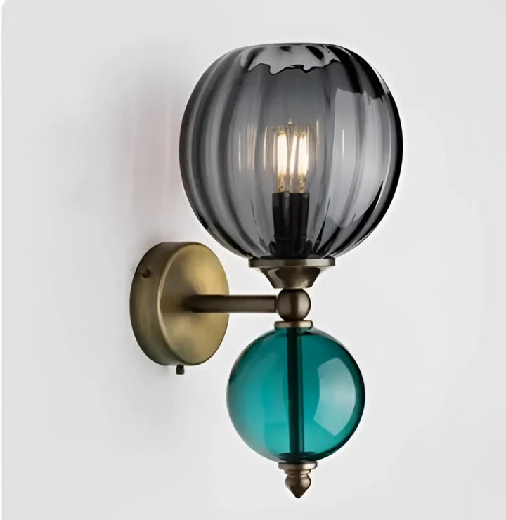Applique murale gloya avec verre teinté gris et teal en globe, détails laiton antique sur bras élégant à deux niveaux
