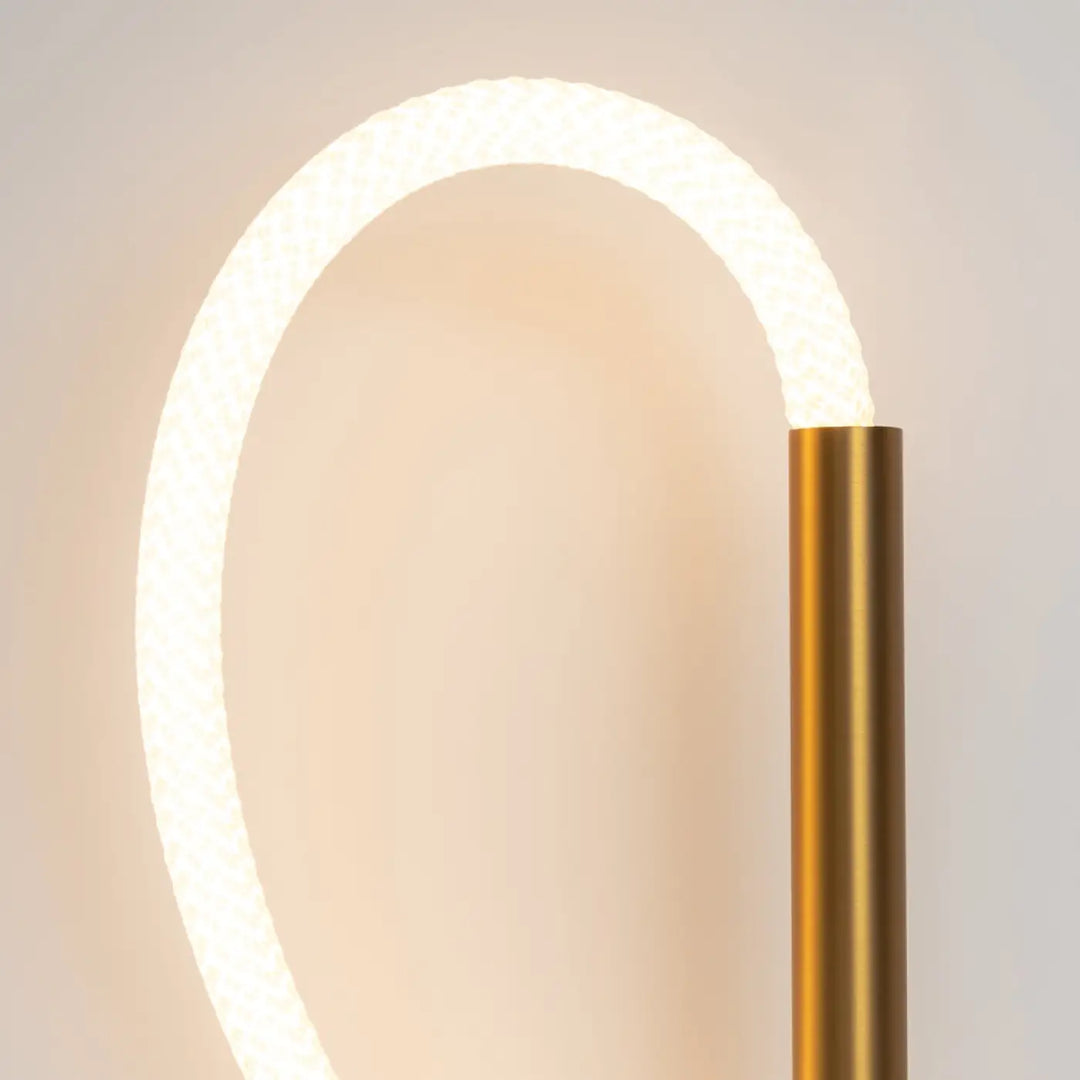 Applique murale led tau avec base cylindrique dorée et arc circulaire blanc texturé éclairé moderne et minimaliste