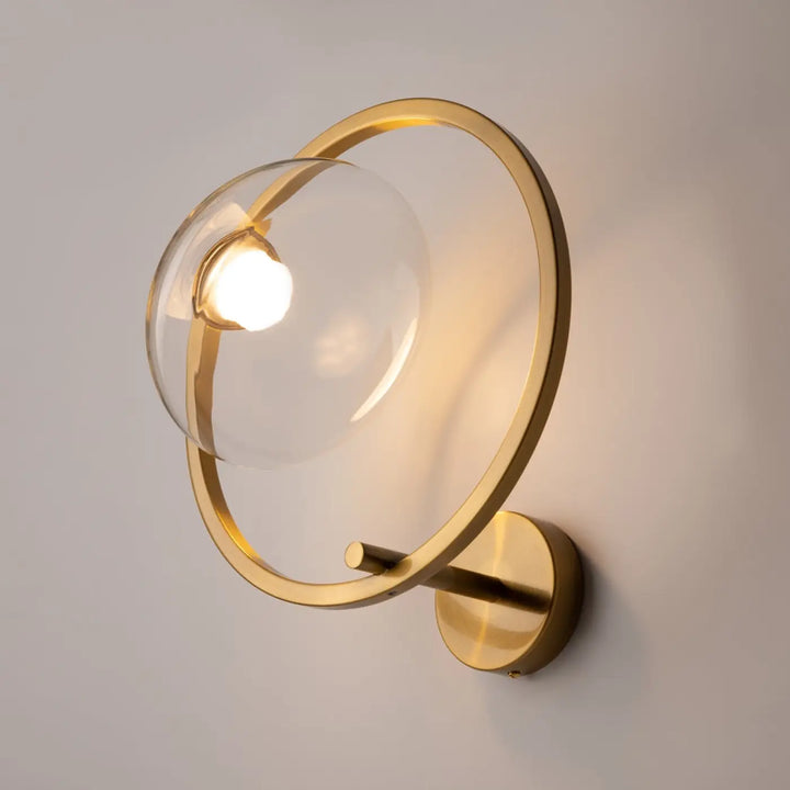Applique murale lunare art déco en doré avec un globe en verre transparent et un anneau circulaire minimaliste