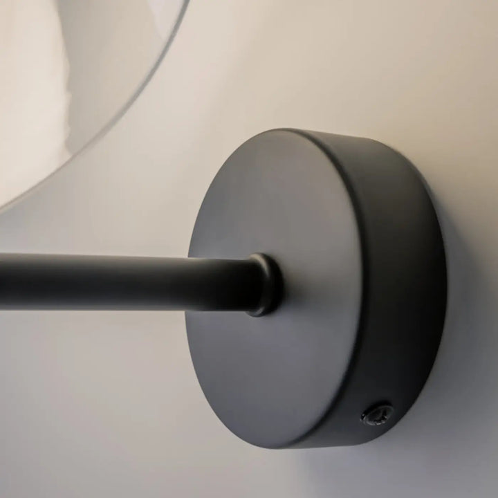 Applique murale memory noire mate avec base circulaire et bras fin dans la collection coupole opaline