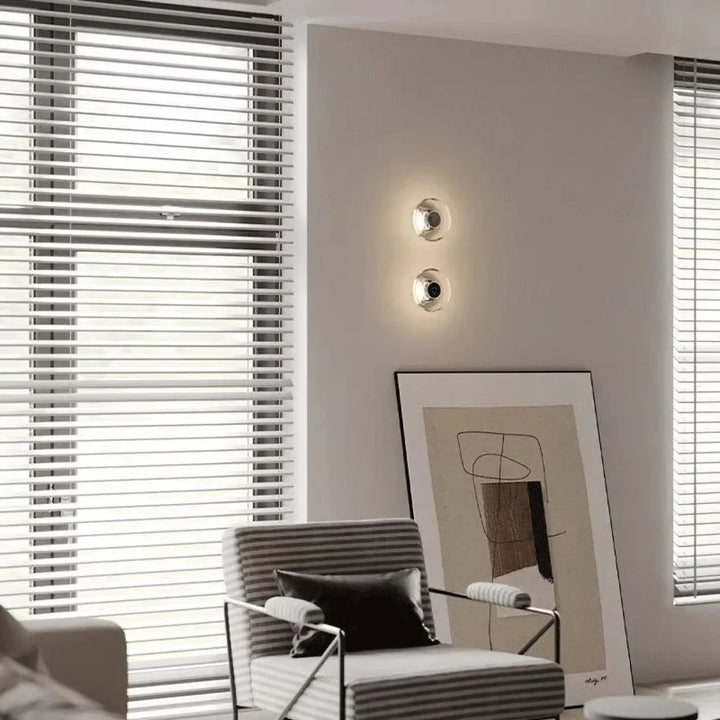 Deux appliques murales argos circulaires en chrome poli avec halo lumineux et verre cristallin diffusant une lumière chaude