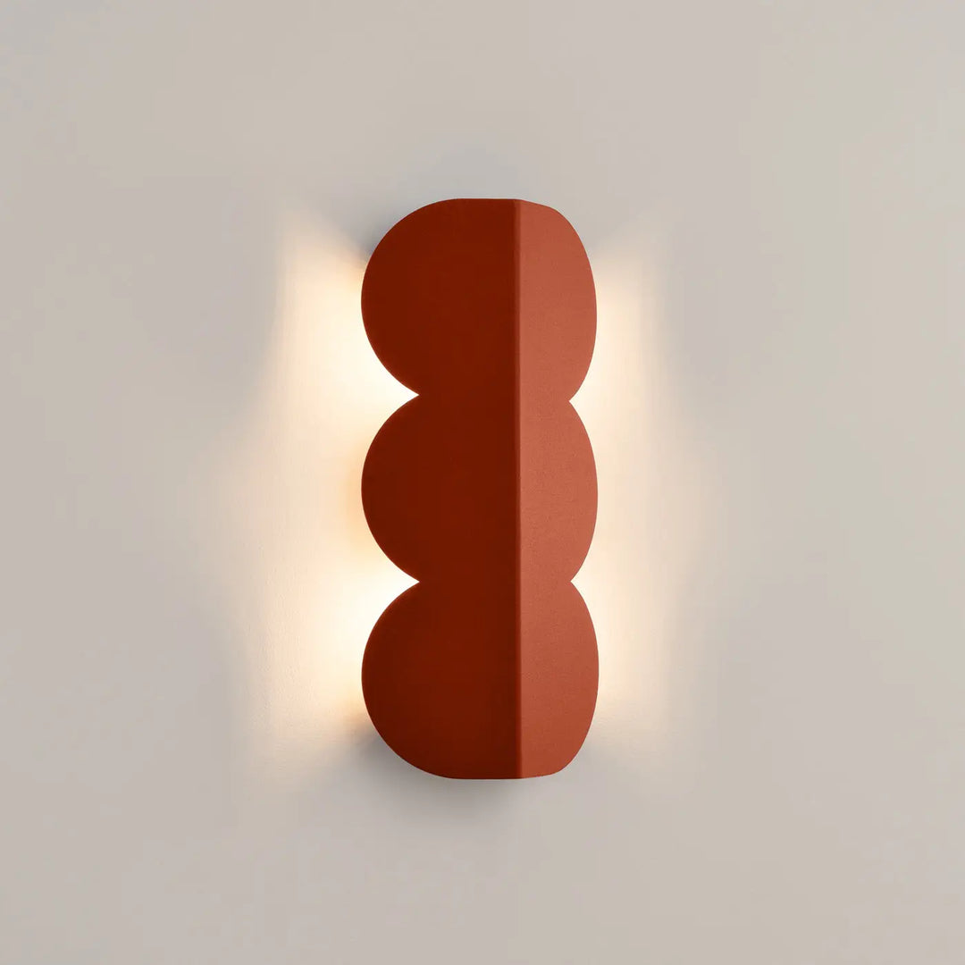 Applique murale BISCUIT ocre rouge allumée, halo sur le mur