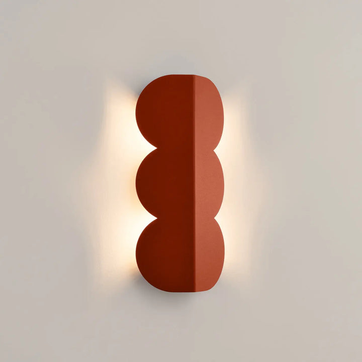 Applique murale BISCUIT ocre rouge allumée, halo sur le mur