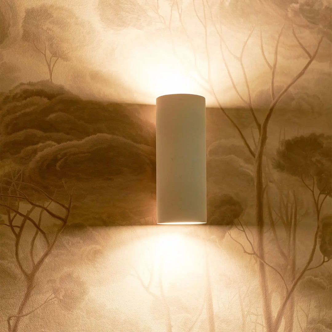 Applique murale parma en plâtre blanc avec design minimaliste éclaire un mur texturé de lumière chaude