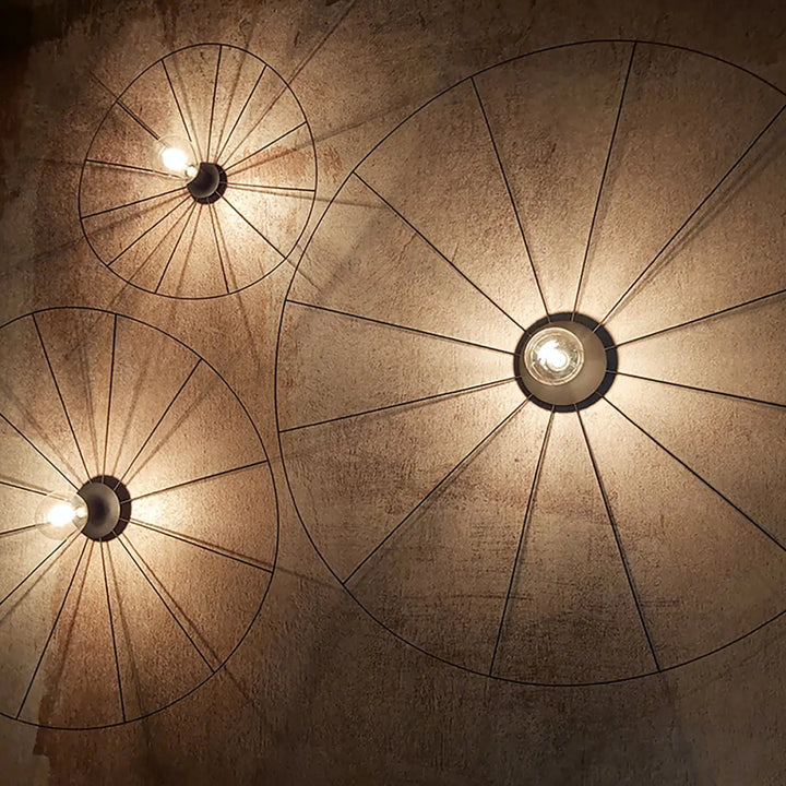 Trois lampes eskola circulaires en fil métallique noir au design rustique industriel de la collection eskola