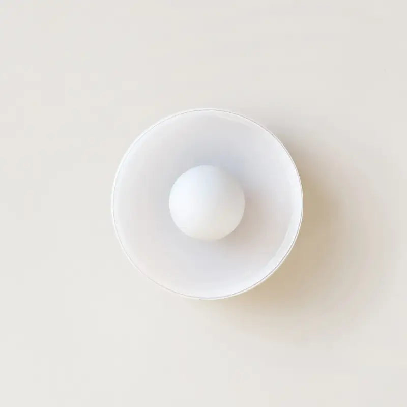 Applique murale ronde en verre avec une boule blanche

