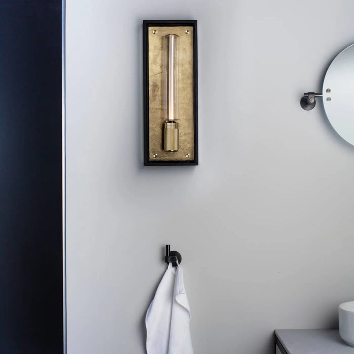 Applique murale Caged Wet en finition laiton dans une salle de bains #couleur_dor