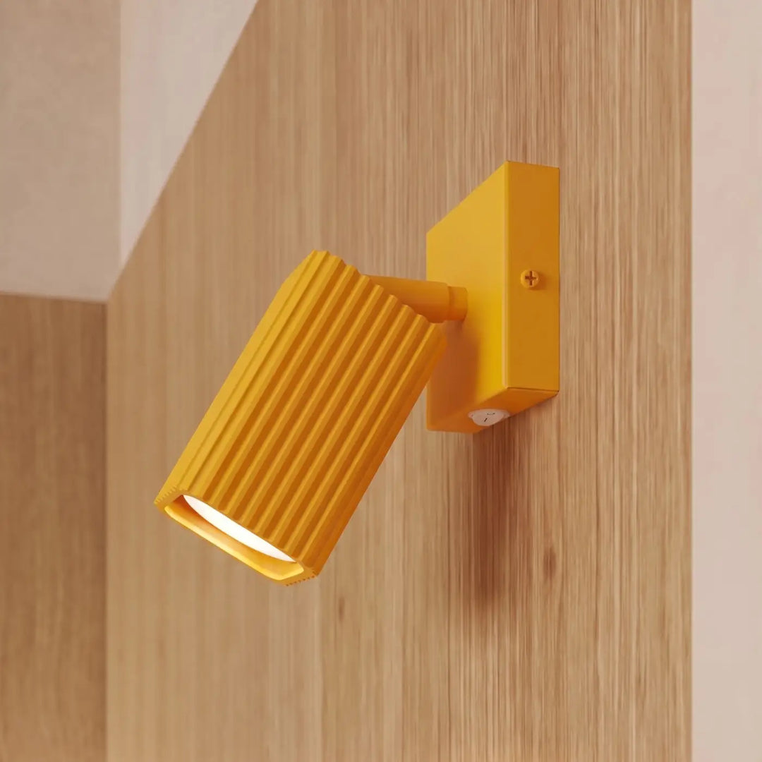 Applique murale Rayo en aluminium jaune à réflecteur rainuré, fixée au mur, vue rapprochée