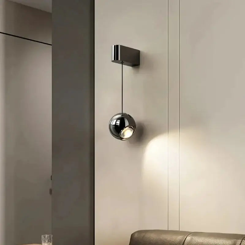 Applique murale suspendue avec une boule projetant la lumière

