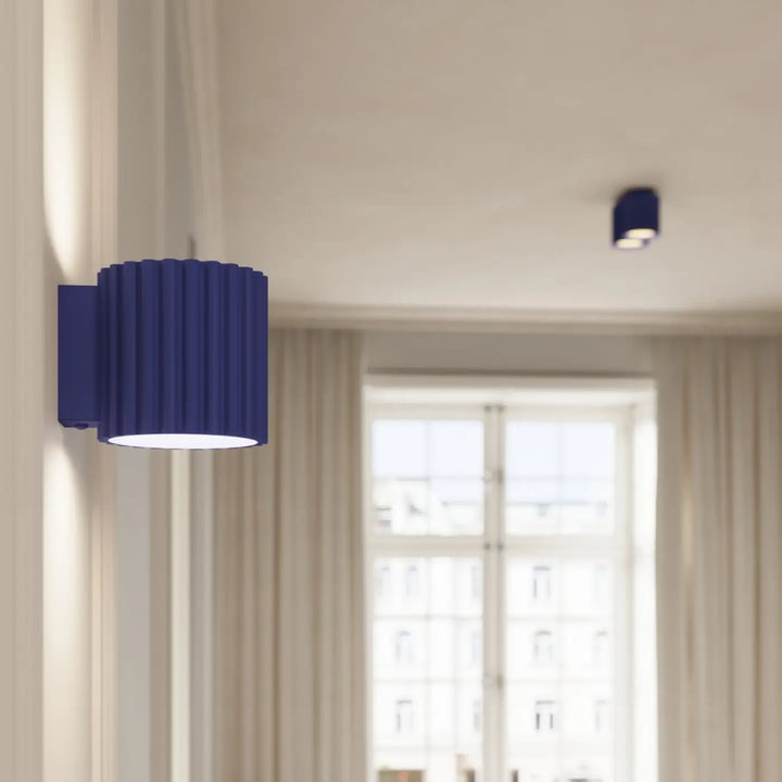 Applique murale aura en bleu profond avec forme unique inspirée et design moderne en cylindre côtelé