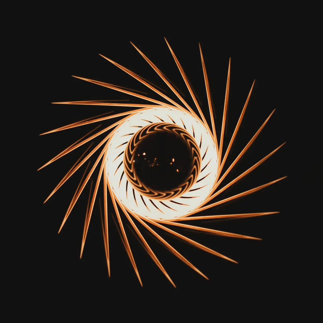 L’applique murale pianumayö en bois fsc présente des traînées lumineuses dorées en spirale partant d’un centre blanc