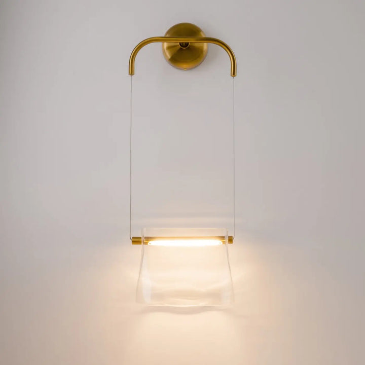 Applique suspendue cabaret en métal finition laiton avec diffuseur en verre transparent émettant une lumière chaude