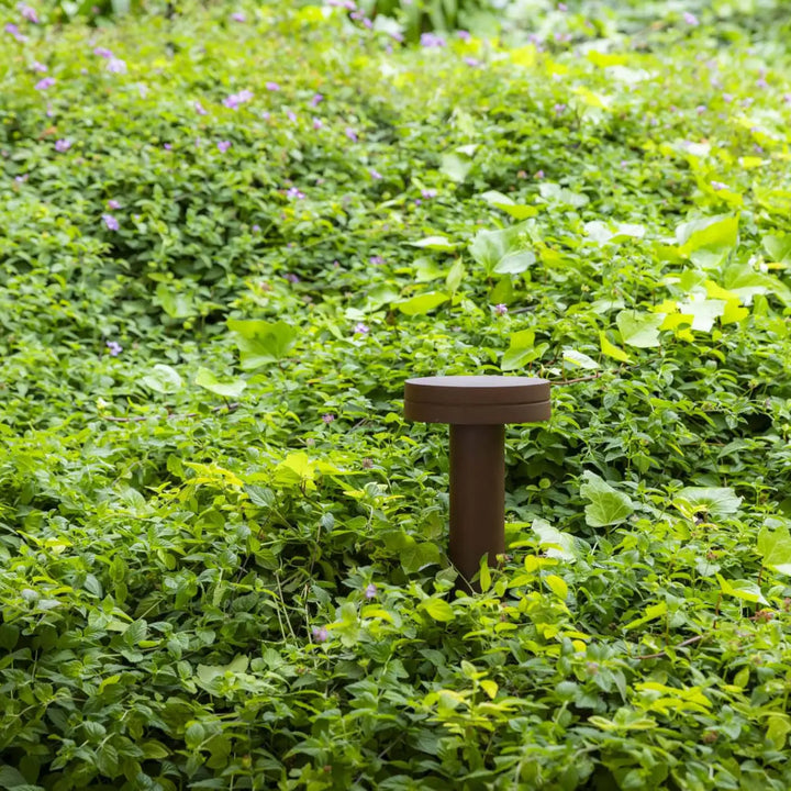 Balise Espot 35 cm brun rouille dans un jardin
