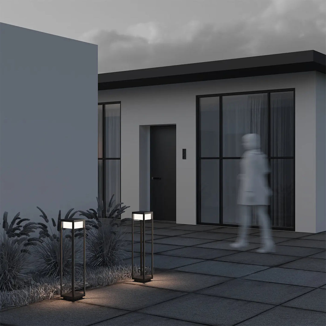 Borne extérieure baker street en aluminium noir avec panneaux en verre carré émettant une lumière chaude