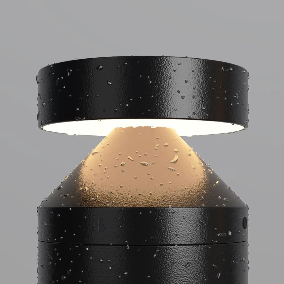 Borne extérieure version basse en acier noir avec lumière led chaude et gouttes d eau sur surface texturée cylindrique