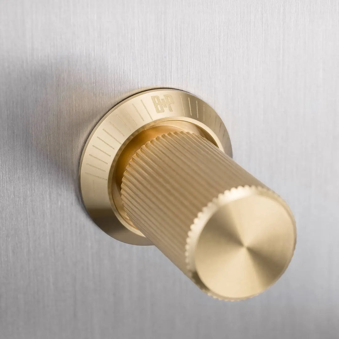 Détail d'un variateur à gravure alignée, finitions acier et laiton #couleur_dor