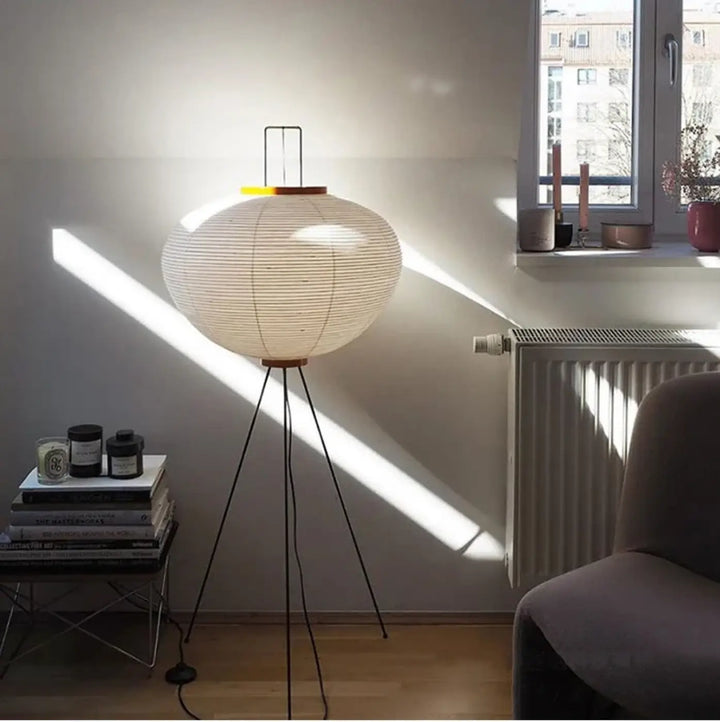 Lampadaire chloe avec base tripode noire et abat-jour sphérique en papier blanc design élégant plus qu’un simple luminaire