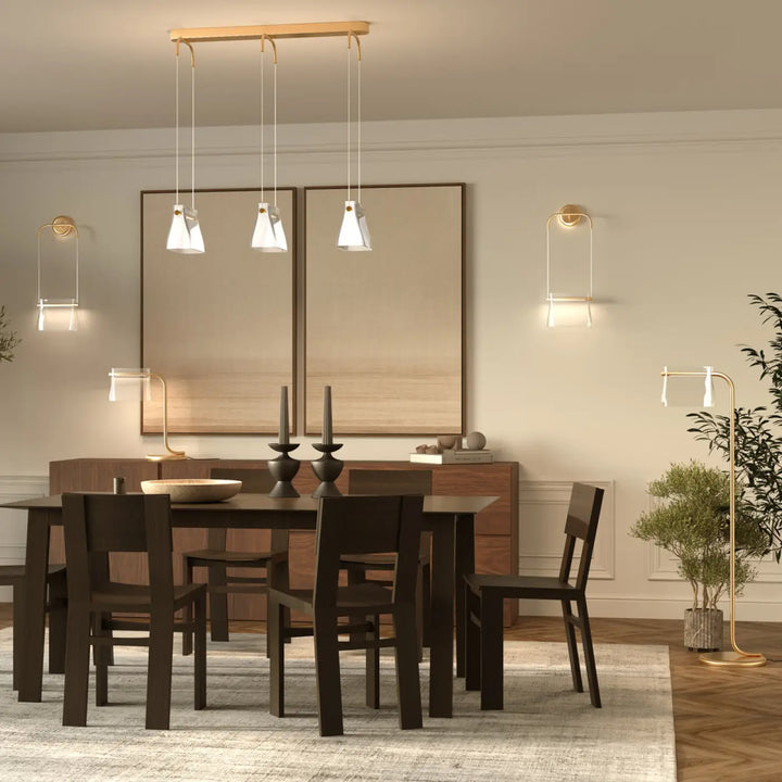 Modern lampadaire cabaret art déco avec verre transparent et suspensions dorées au-dessus d’une table en bois sombre
