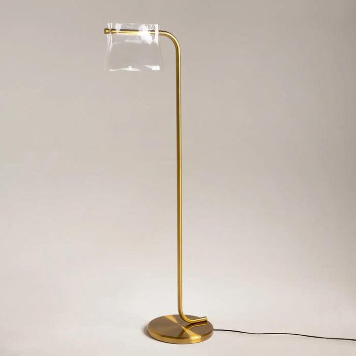 Lampadaire cabaret art déco en finition or avec tige incurvée et abat-jour en verre transparent minimaliste