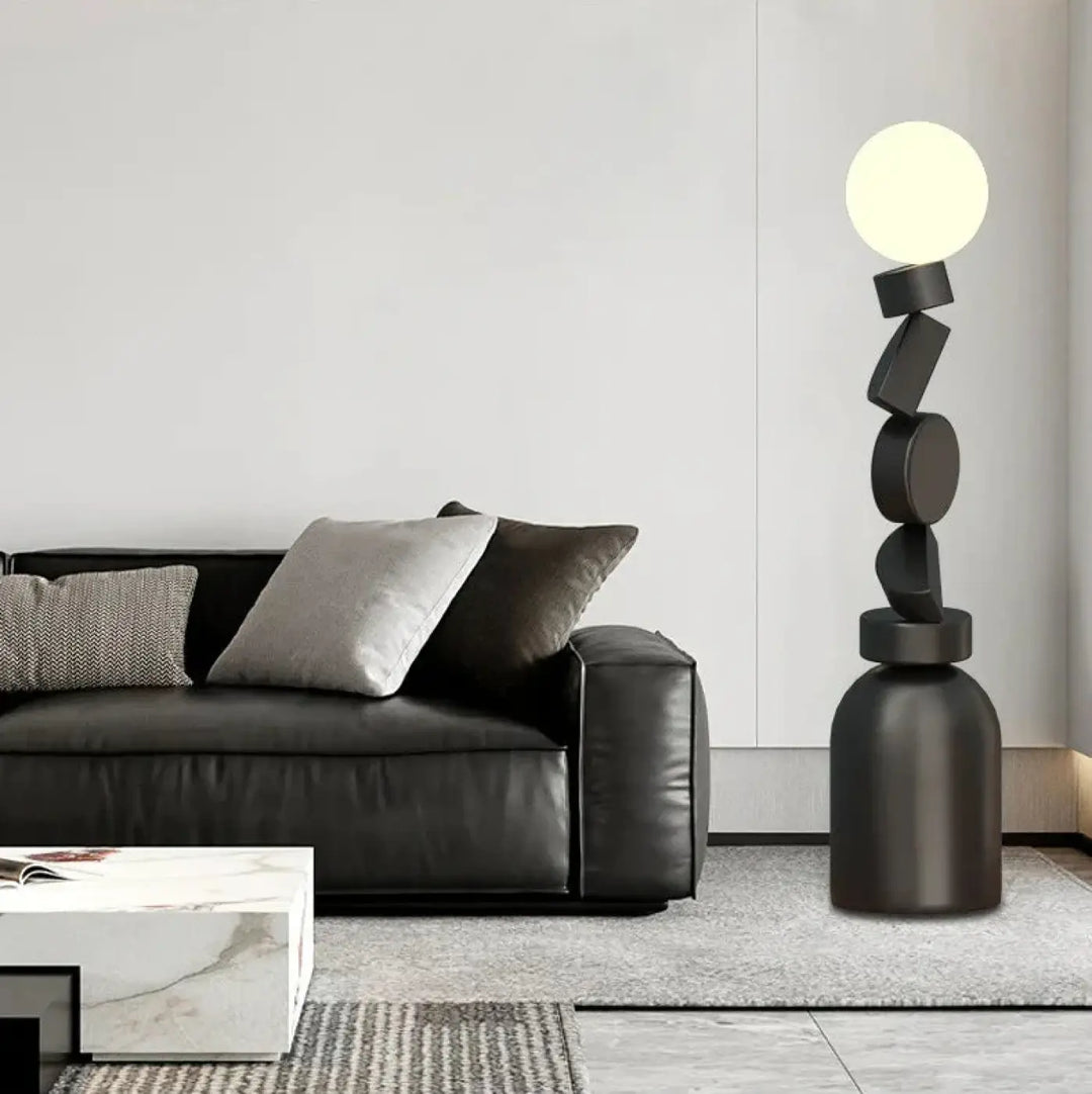 Lampadaire noir géométrique totex avec formes circulaires et rectangulaires empilées et ampoule sphérique lumineuse detail decorate root