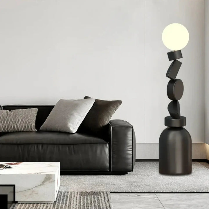 Lampadaire noir géométrique totex avec formes circulaires et rectangulaires empilées et ampoule sphérique lumineuse detail decorate root
