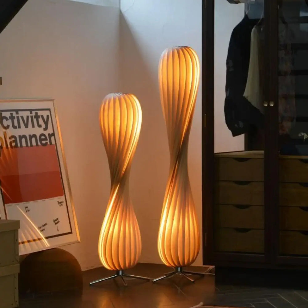 Lampadaire marron design sculptural avec deux lampes sur pied en bois torsadé émettant une lueur dorée chaleureuse