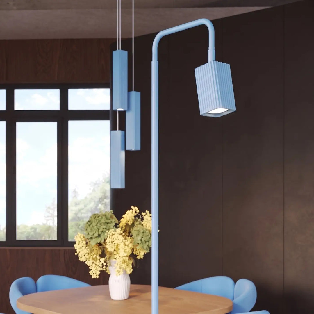 Lampadaire Rayo bleu azur à spot rainuré près d'une table à manger