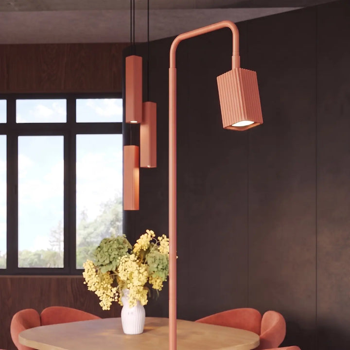 Lampadaire Rayo ocre rouge à spot rainuré près d'une table à manger