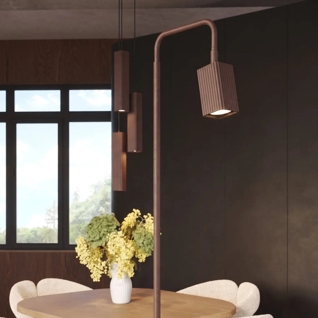 Lampadaire Rayo marron à spot rainuré près d'une table à manger