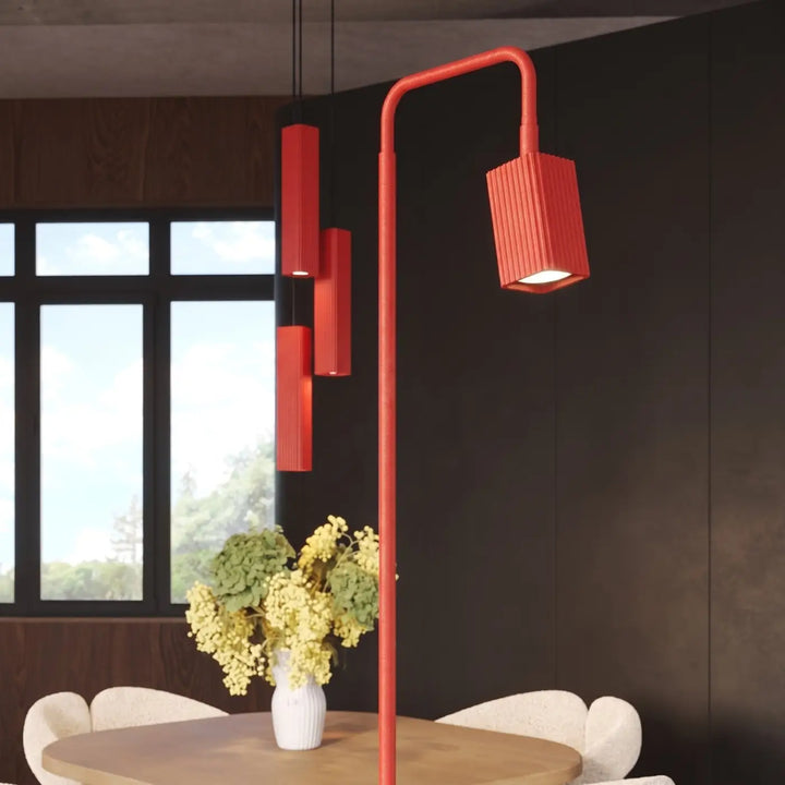 Lampadaire Rayo rouge à spot rainuré près d'une table à manger