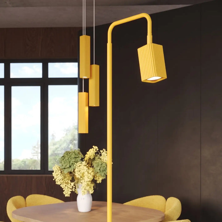 Lampadaire Rayo jaune à spot rainuré près d'une table à manger