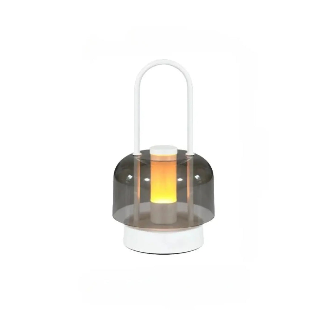 Lampe de table Cristo avec dôme gris translucide et base blanche émettant une douce lumière orange, idéal comme night light