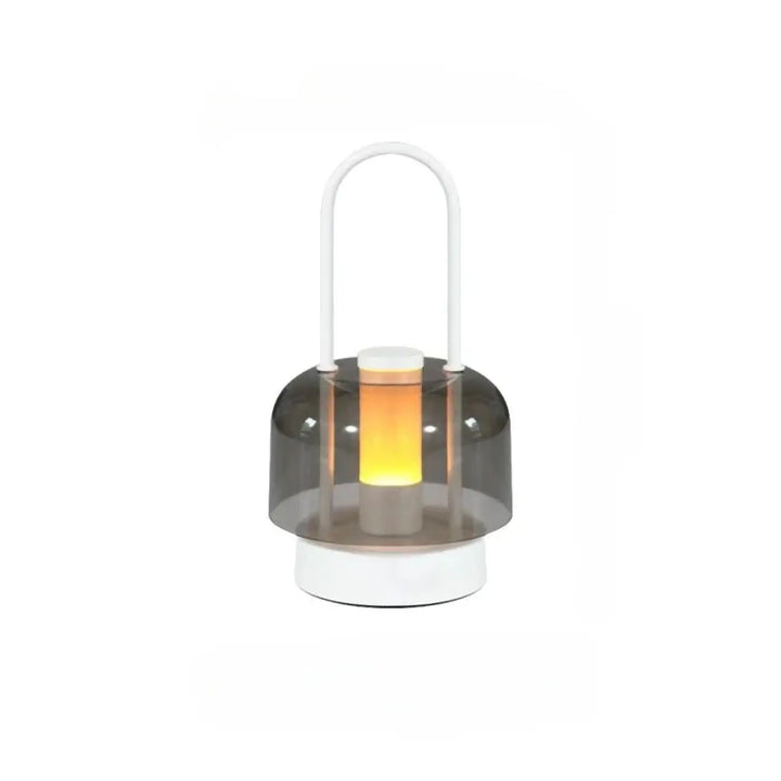 Lampe de table Cristo avec dôme gris translucide et base blanche émettant une douce lumière orange, idéal comme night light